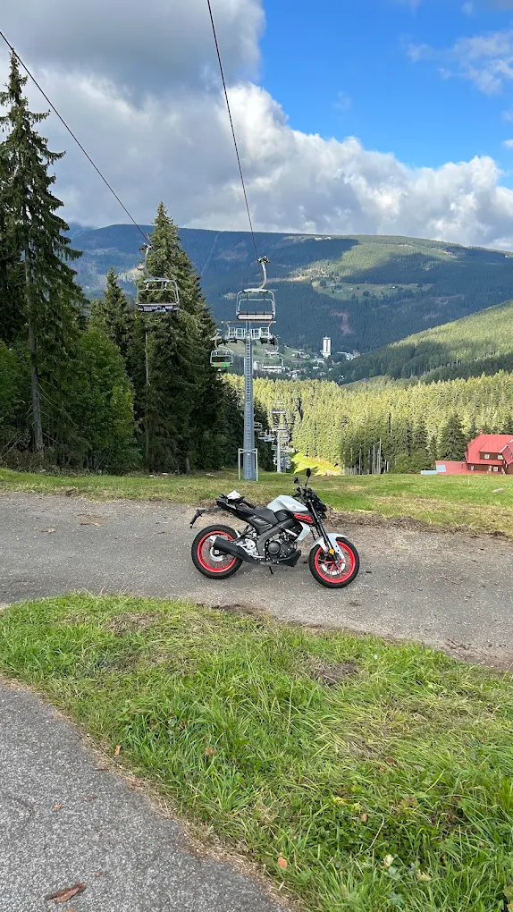 Motocykl na tle kolejki i górskiej doliny