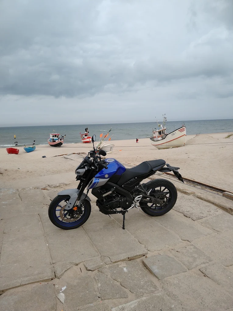 Yamaha MT zaparkowana przy plaży i łodziach rybackich